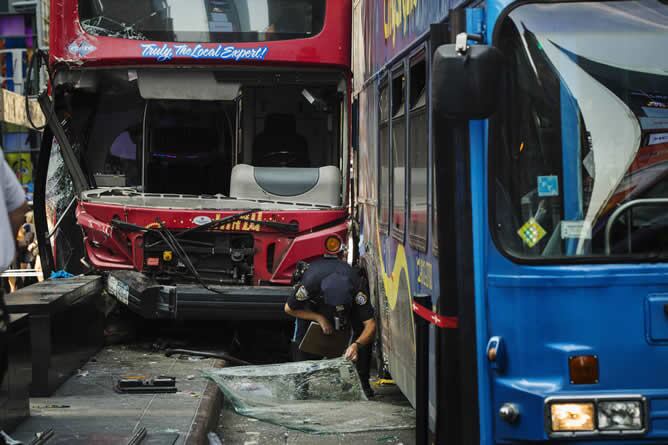 Un policía de Nueva York inspecciona un parabrisas roto en la escena de un choque entre dos autobuses turísticos en la región de Times Square de Nueva York