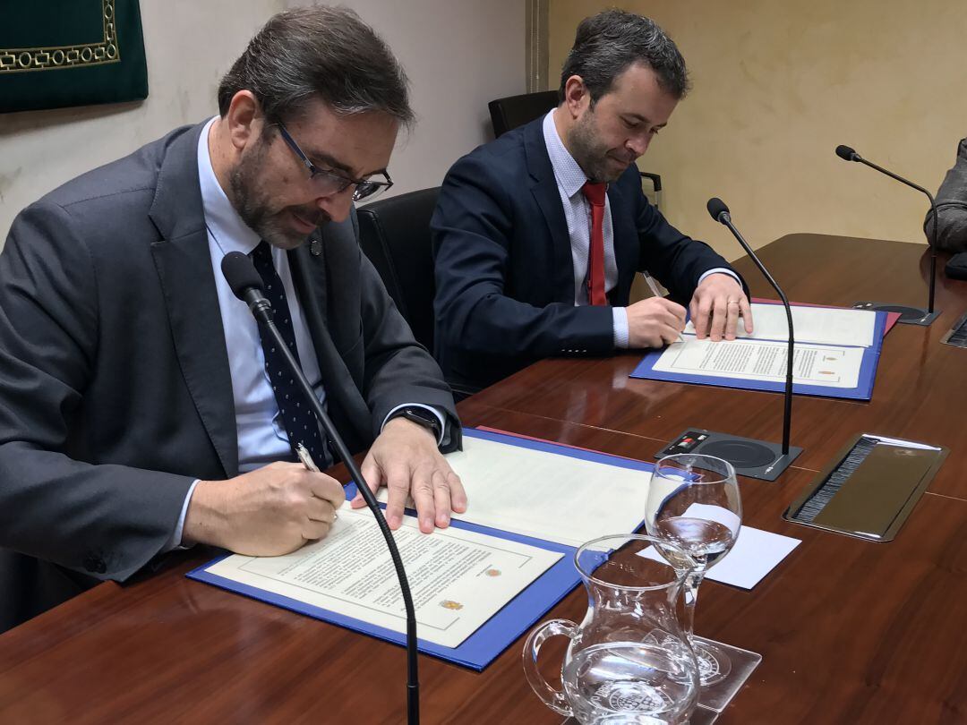 Momento de la firma del rector de la UJA, Juan Gómez y el alcalde de Jaén, Julio Millán.