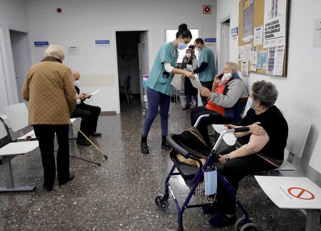 Una sanitaria entrega los certificados de vacunación a las personas mayores que se han vacunado en el ambulatorio de la calle Chile de València. 