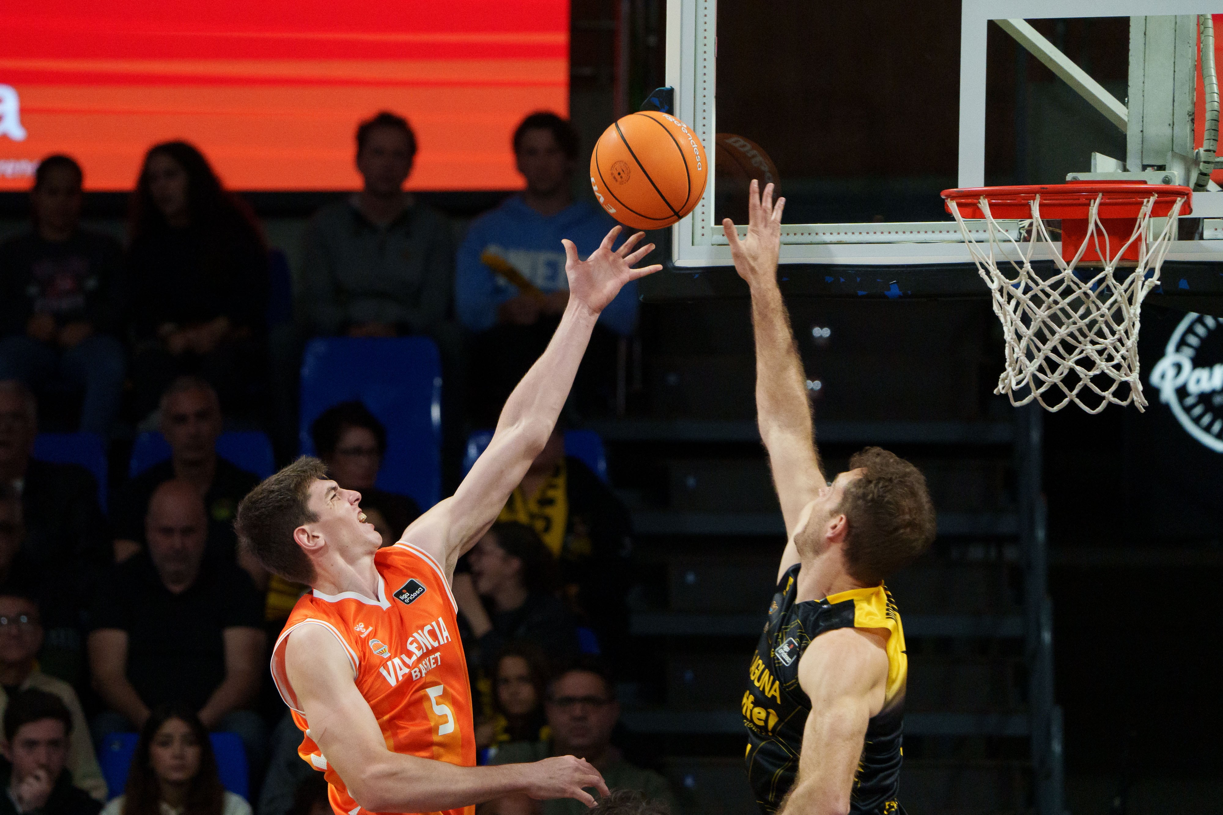 TENERIFE, 14/03/2026.- El base del Valencia Basket, Sergio de Larrea (i), entra a canasta ante el ala-pívot del La Laguna Tenerife, Tim Abromaitis (d), durante el partido correspondiente a la Liga Endesa que se celebra este sábado en el Pabellón Santiago Martín de La Laguna (Tenerife), entre el La Laguna Tenerife y el Valencia Basket EFE/Ramón de la Rocha