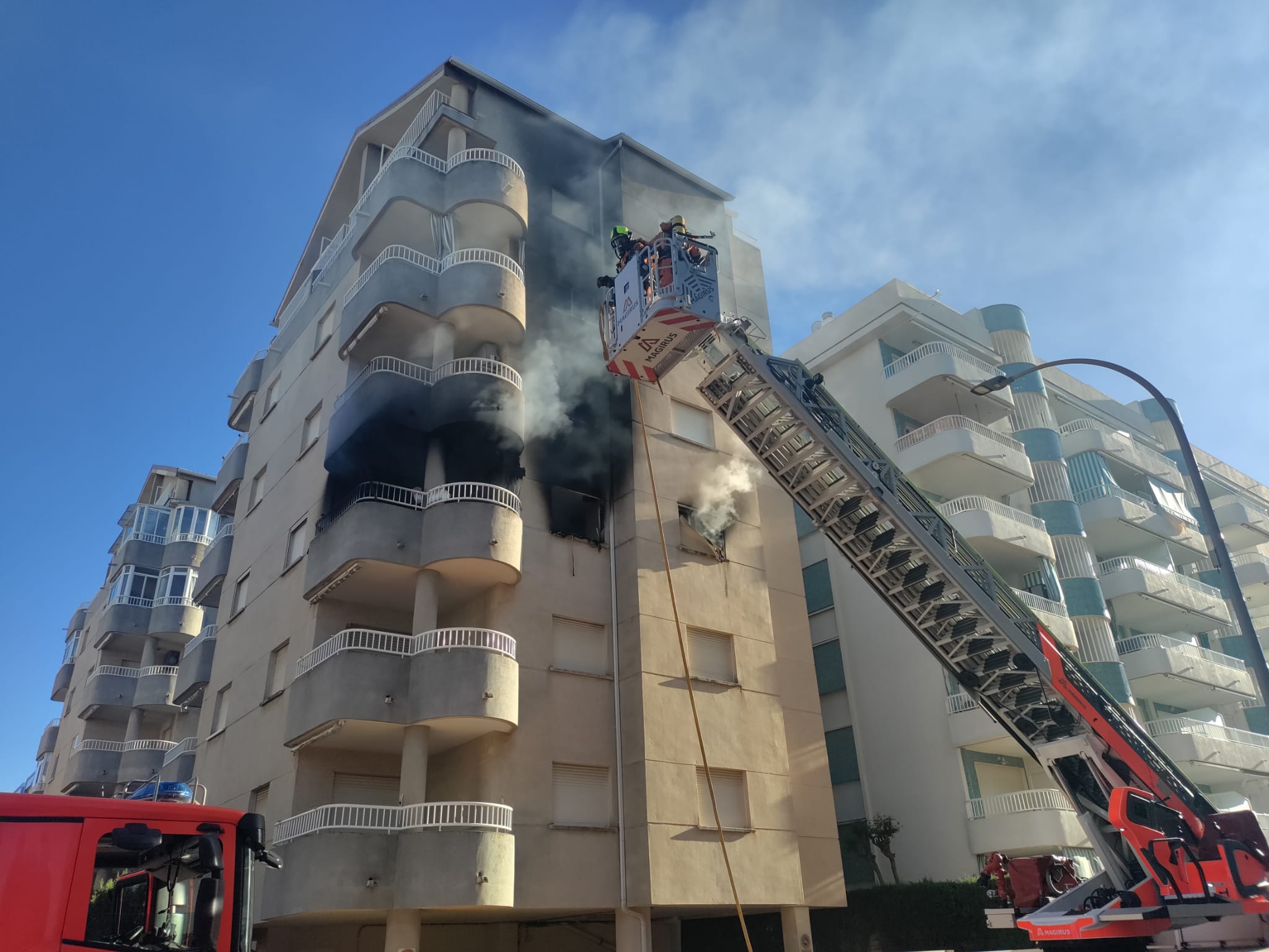 Momento de intervención de los bomberos en el incendio de la vivienda en la calle Sant Pere de la playa de Daimús