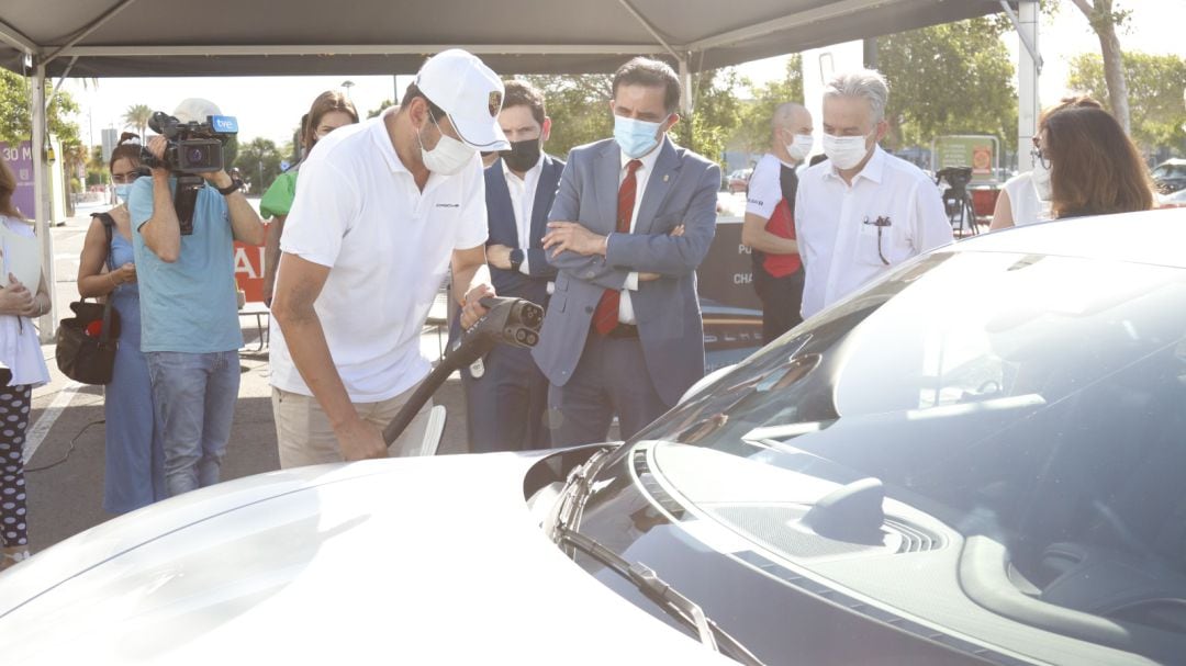 Un operario procede a cargar un vehículo eléctrico en presencia del alcalde de Murcia