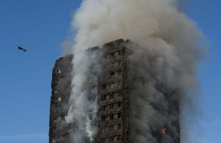 Un helicóptero sobrevuela la Torre Grenfell arrasada por un incendio en Lancaster West Estate, Londres.