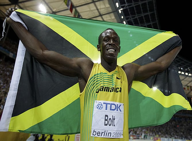 Bolt recoge una bandera de Jamaica tras su triunfo en Berlín