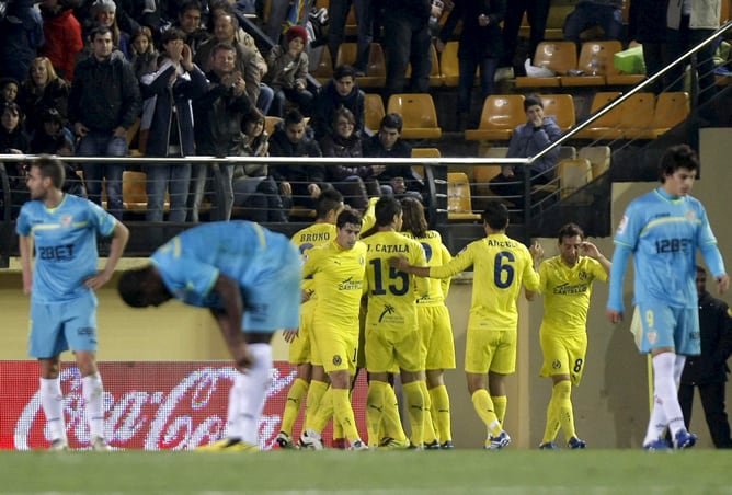 Los jugadores del Villarreal celebran el primer gol del equipo castellonense, durante el encuentro correspondiente a la decimocuarta jornada de primera división, que les enfrenta esta noche al Sevilla en el estadio castellonense del Madrigal