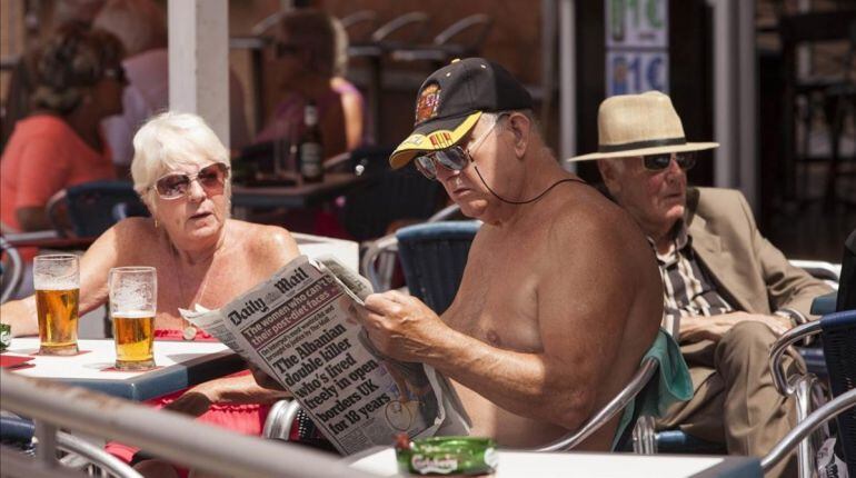 Británicos leyende prensa del Reino Unido en una terraza de Benalmádena