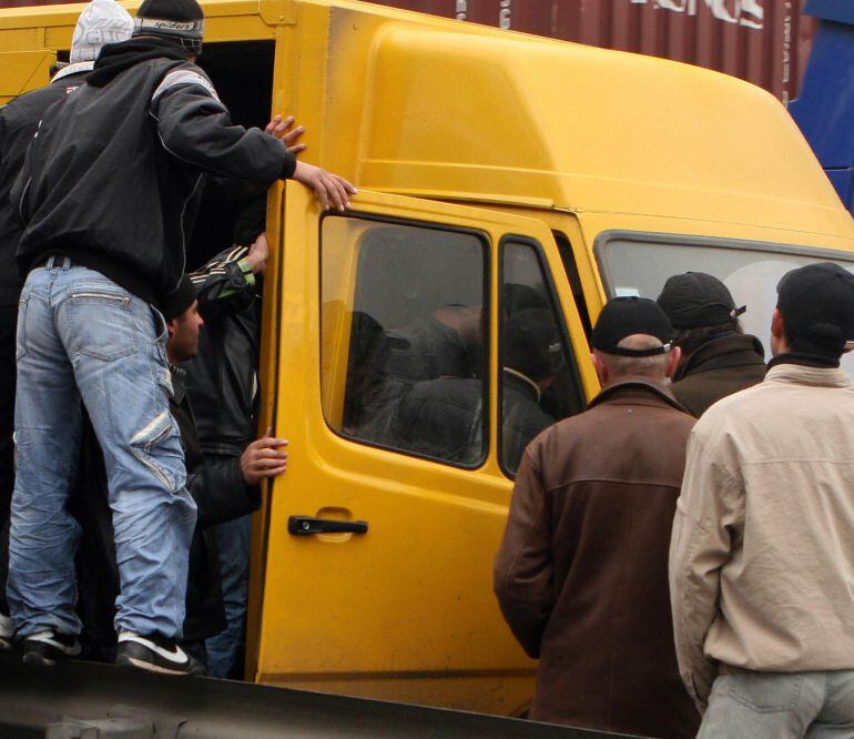 Trabajadores inmigrantes se suben a una furgoneta para trasladarles al lugar de trabajo.