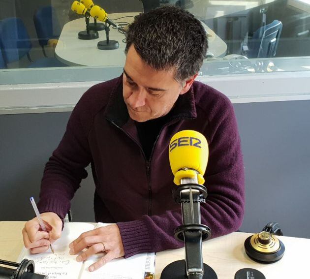 Martí Gironell firmant un exemplar del seu llibre a SER Tarragona