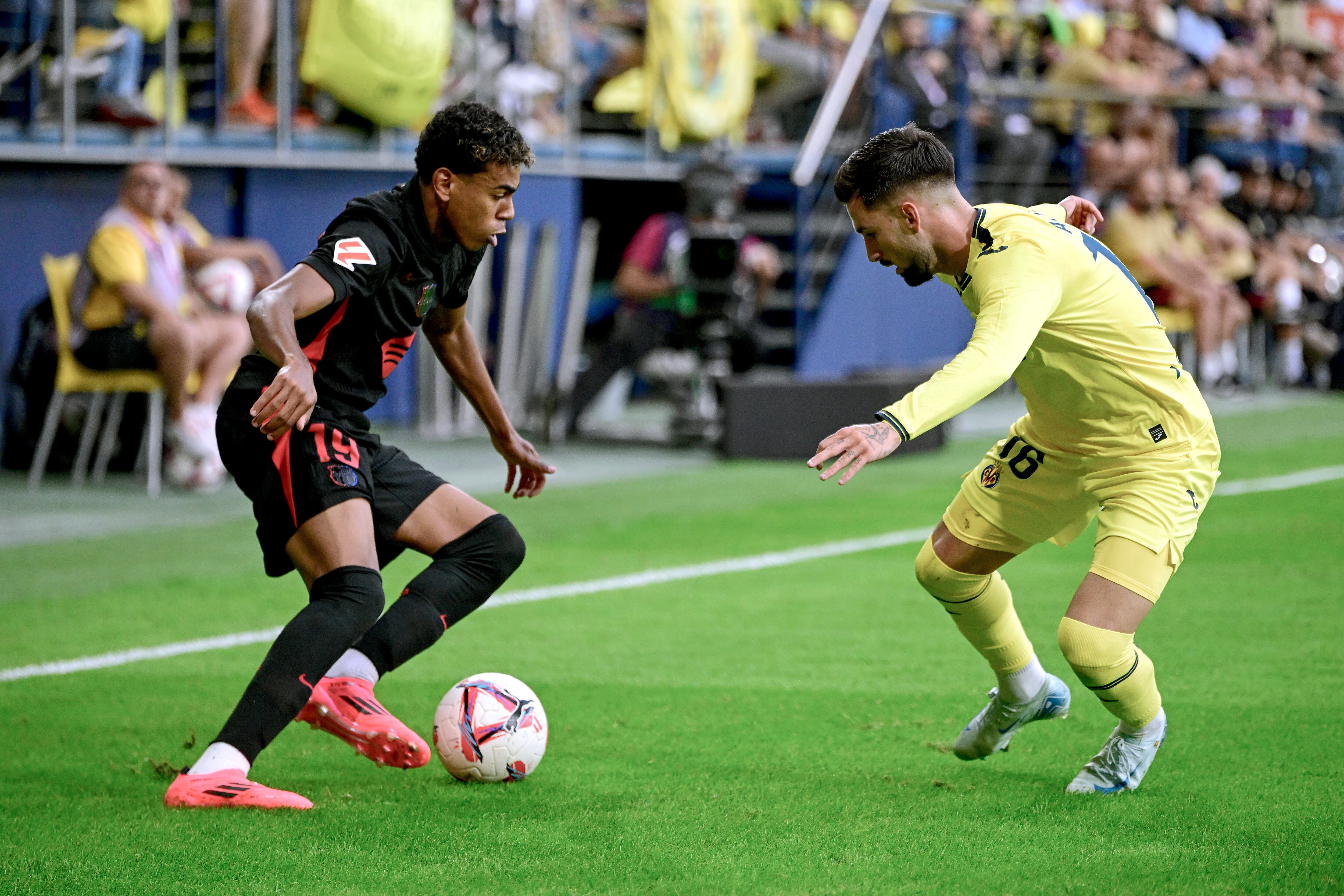 VILLARREAL, 22/09/2024.- El delantero del FC Barcelona, Lamine Yamal (i), con el balón ante el delantero del Villarreal, Álex Baena, durante el encuentro correspondiente a la sexta jornada de Laliga EA Sports que disputan hoy Domingo FC Barcelona y Villarreal en el estadio de La Cerámica, en la localidad castellonense. EFE / Andreu Esteba.
