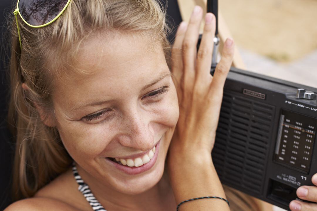 Chica se ríe al escuchar la radio