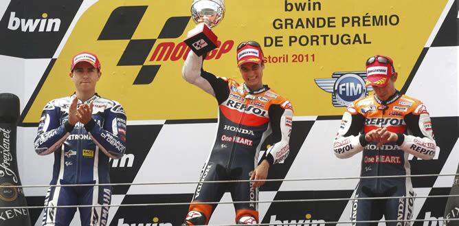 El piloto español de MotoGP de Repsol Honda, Dani Pedrosa (c), celebra en el podio la victoria conseguida en el Gran Premio de Portugal, junto al español de Yamaha, Jorge Lorenzo (izda), segundo, y al australiano de Repsol Honda, Casey Stoner, en el circu