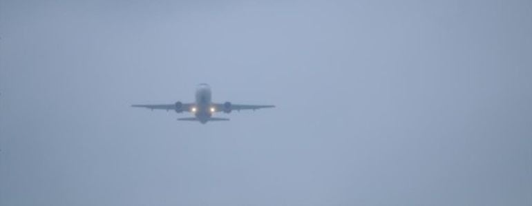 Imagen de archivo de un avión entre la niebla