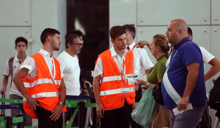 Personal de AENA informa a los viajeros en el aeropuerto de El Prat de Barcelona.