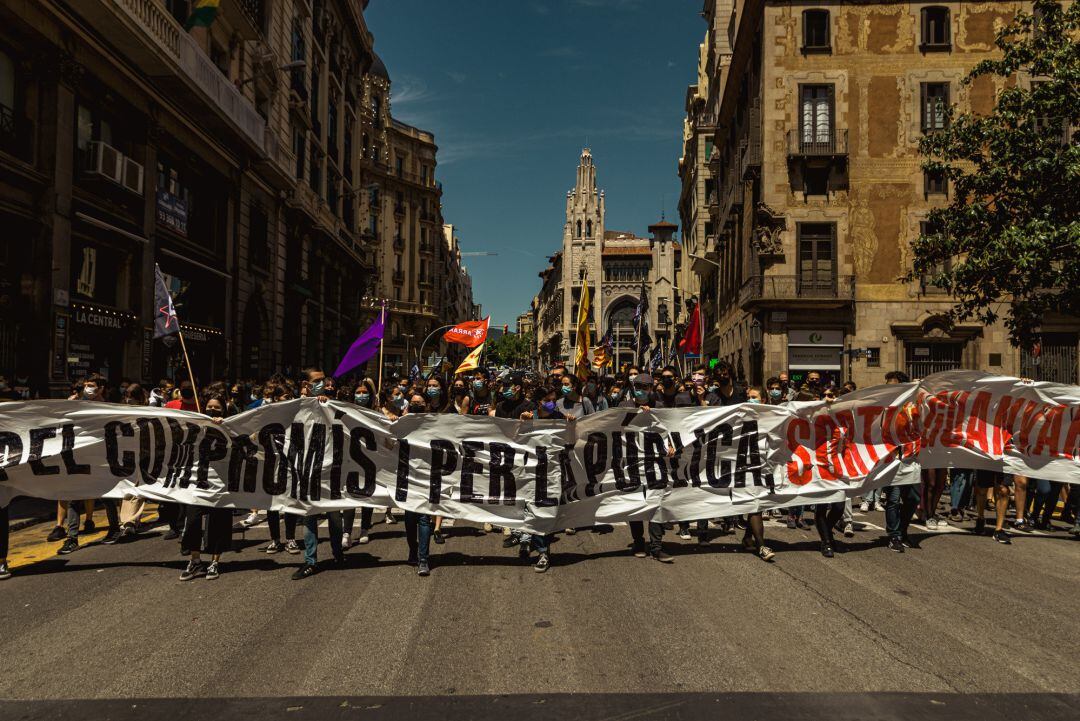 13 May 2021, Spain, Barcelona: Striking Catalan students march with a banner and flags as they protest the education crisis during the continuous spread of the coronavirus virus. 