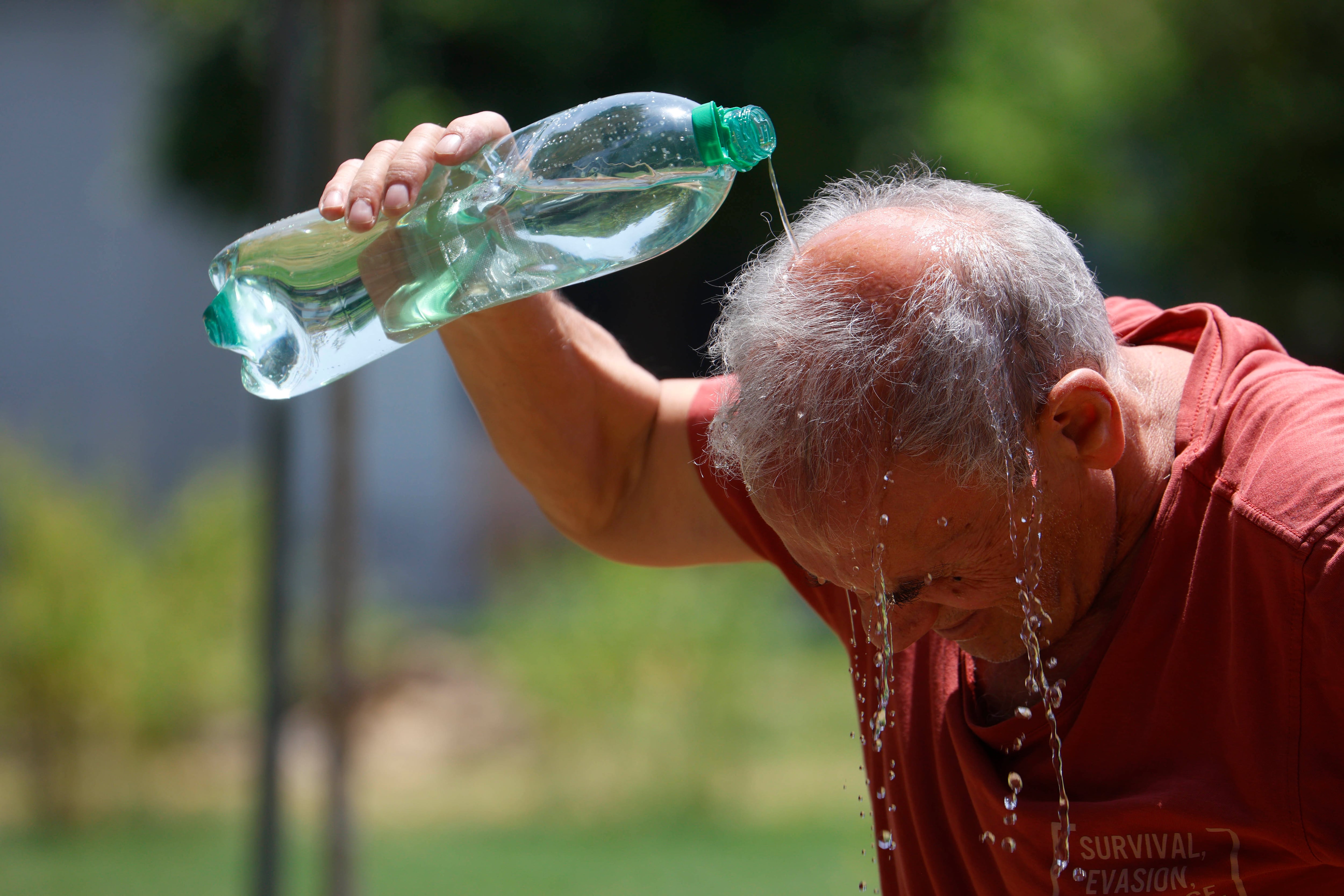 GRAFAND9840. CÓRDOBA, 01/07/2025.-Un hombre se refresca con agua de una botella en la calle en Córdoba marca 43 grados este martes en el que continúa la ola de calor un día más con todo el país en alerta ante la previsión de máximas este martes de hasta 43 grados en puntos de Andalucía. EFE/Salas
