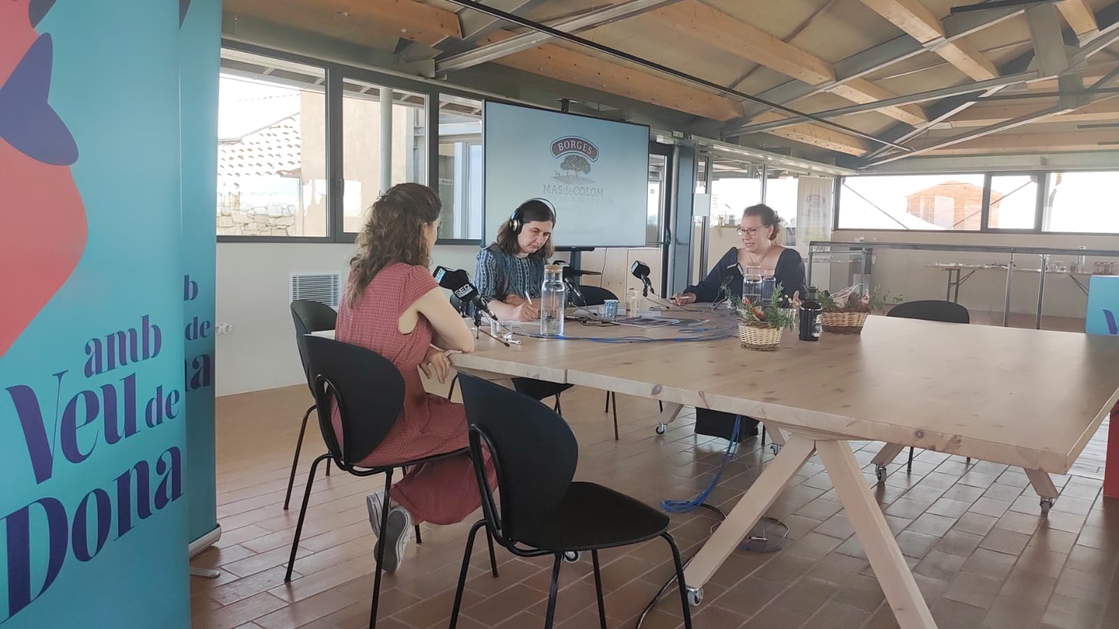 Mireia Vilalta (d&#039;esquena), Mercè March i Elena de Carandini Raventós, durant la taula d&#039;anàlisi sobre &quot;La dona en el món de les arts&quot; durant el programa especial Amb Veu De Dona des de Mas de Colom-Casa Borges.