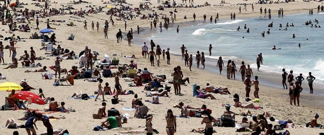 Cientos de personas disfrutan de un día soleado en la playa de La Zurriola de San Sebastián