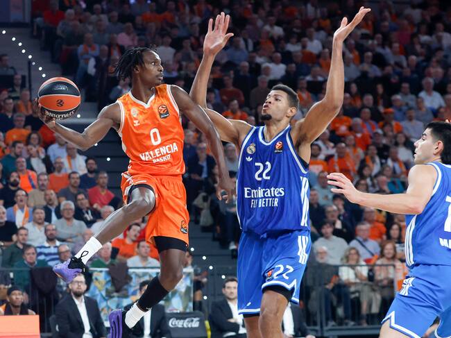VALENCIA, 11/11/2025.- El base del Valencia Brancou Badio (i) juega un balón ante Edy Tavares (c), del Real Madrid, durante el partido de la décima jornada de la fase regular de la EuroLiga de baloncesto que Valencia Basket y Real Madrid disputan este martes en el Roig Arena. EFE/Miguel Ángel Polo