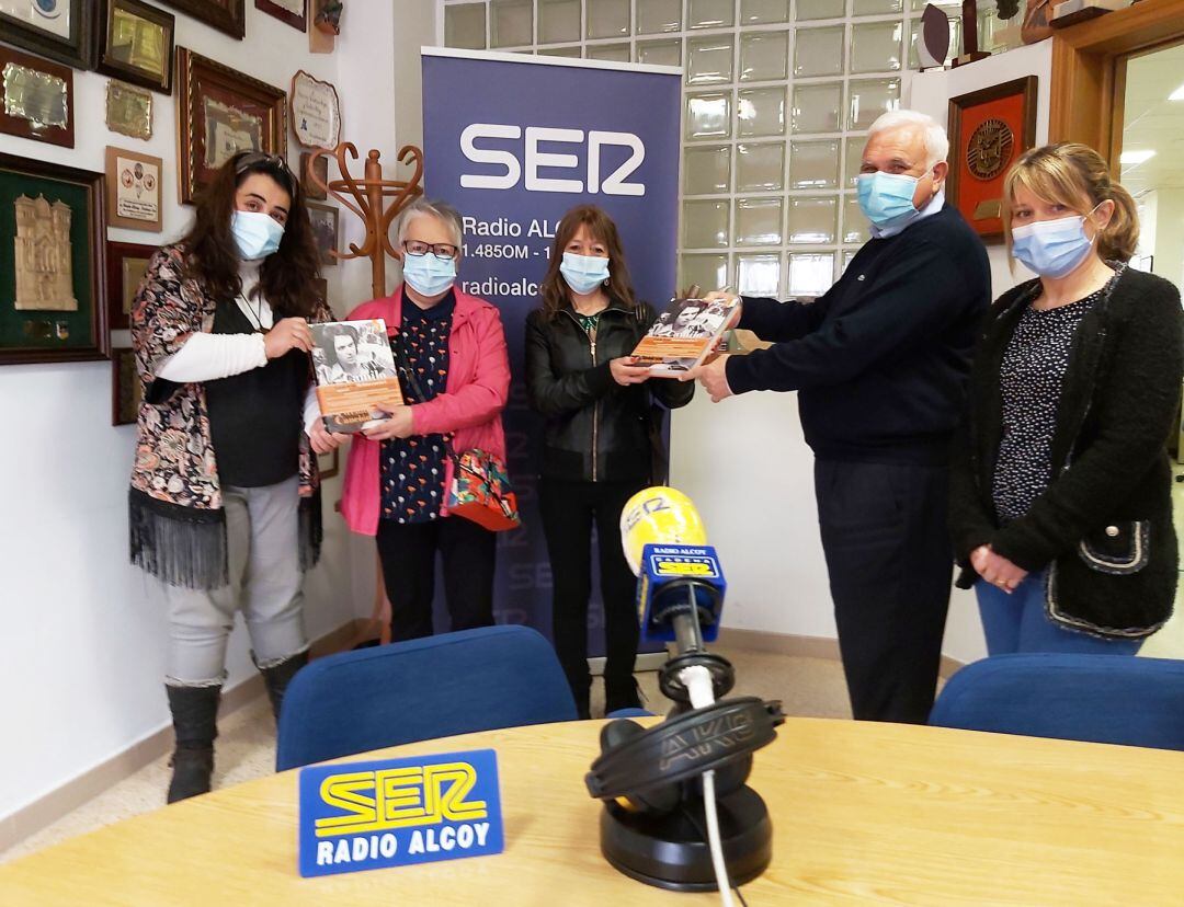 Tesa Zález y Juan Jordá y Celia Úbeda entregan dos ejemplares del libro a Amalia Carbonell y Montse Torrella
