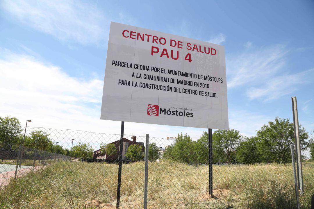 Cartel sobre el terreno cedido a la Comunidad de Madrid para la construcción del centro de salud del PAU-4