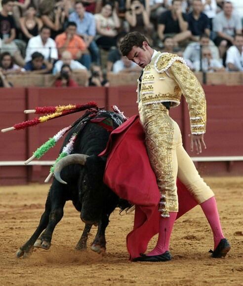 El novillero madrileño Fernando Adrián, en un trincherazo al primer novillo de su lote el domingo en la Maestranza.