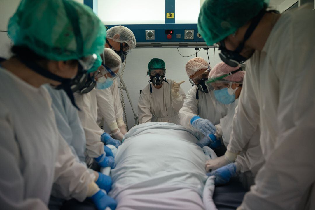 Varios sanitarios con un enfermo de COVID-19 en la UCI.