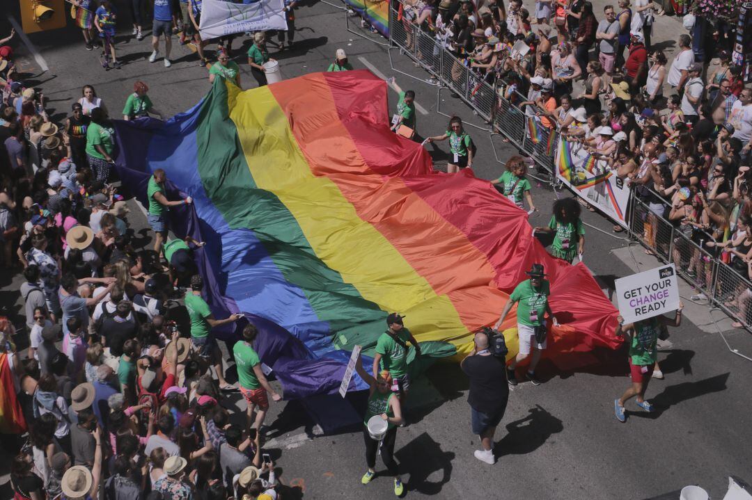 Manifestantes portan una bandera de reconocimiento de los derechos del colectivo LGTBI+