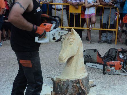 Un motoserrista talla la cabeza de un caballo en el festival de la Sierra y el Hombre