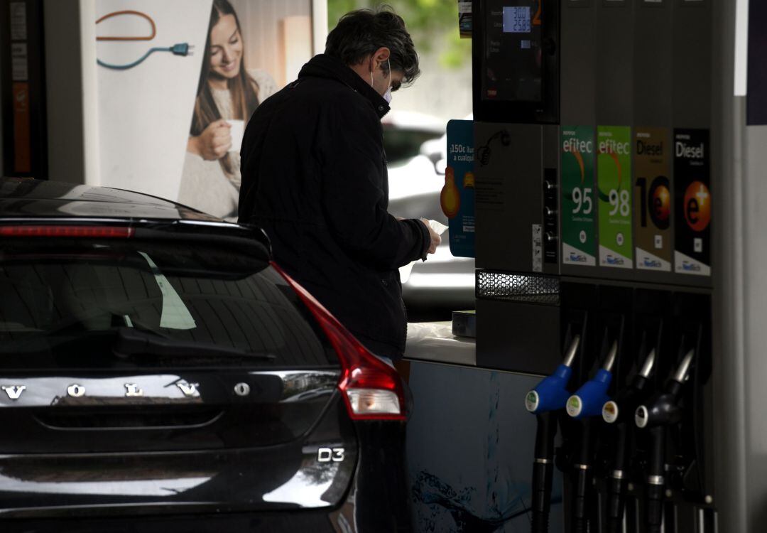 Un hombre echa gasolina a su coche en una gasolinera.