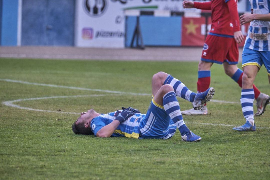 Adeva se duele sobre el verde tras una acción de choque frente a un jugador numantino