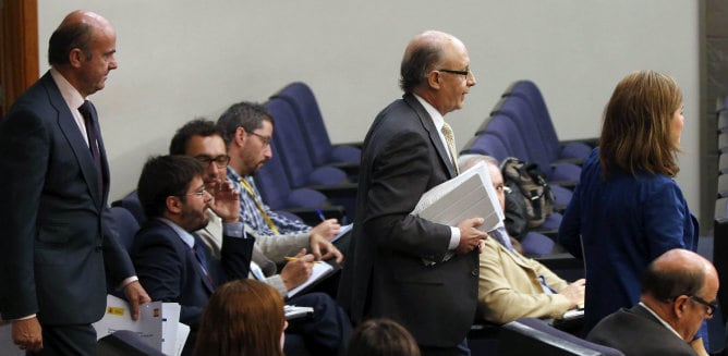 La vicepresidenta del Gobierno, Soraya Sáenz de Santamaría, junto al ministro de Hacienda, Cristóbal Montoro, y el ministro de Economía, Luis de Guindos, a la llegada a la rueda de prensa que han ofrecido tras la reunión del Consejo de Ministros.