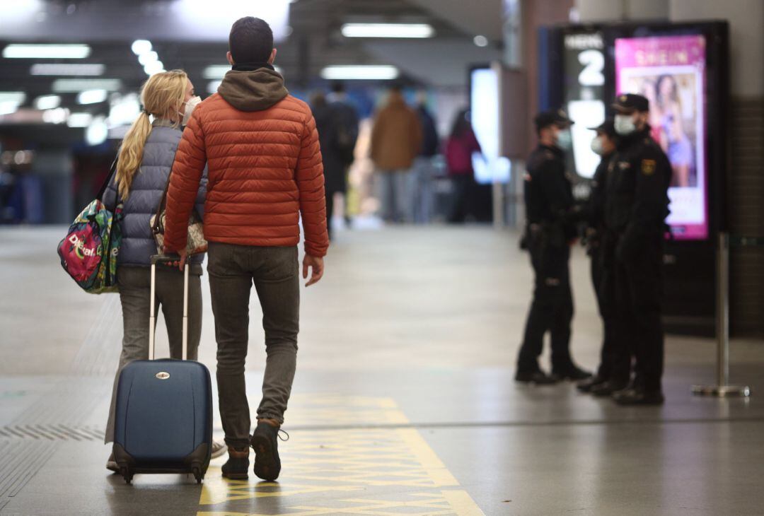 Agentes la Policía Nacional realizan controles de movilidad en la estación de AVE Puerta de Atocha durante el primer día de cierre perimetral por el puente de la Constitución en Madrid (España)