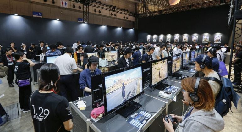 Varios visitantes prueban diferentes videojuegos durante el Tokyo Game show.