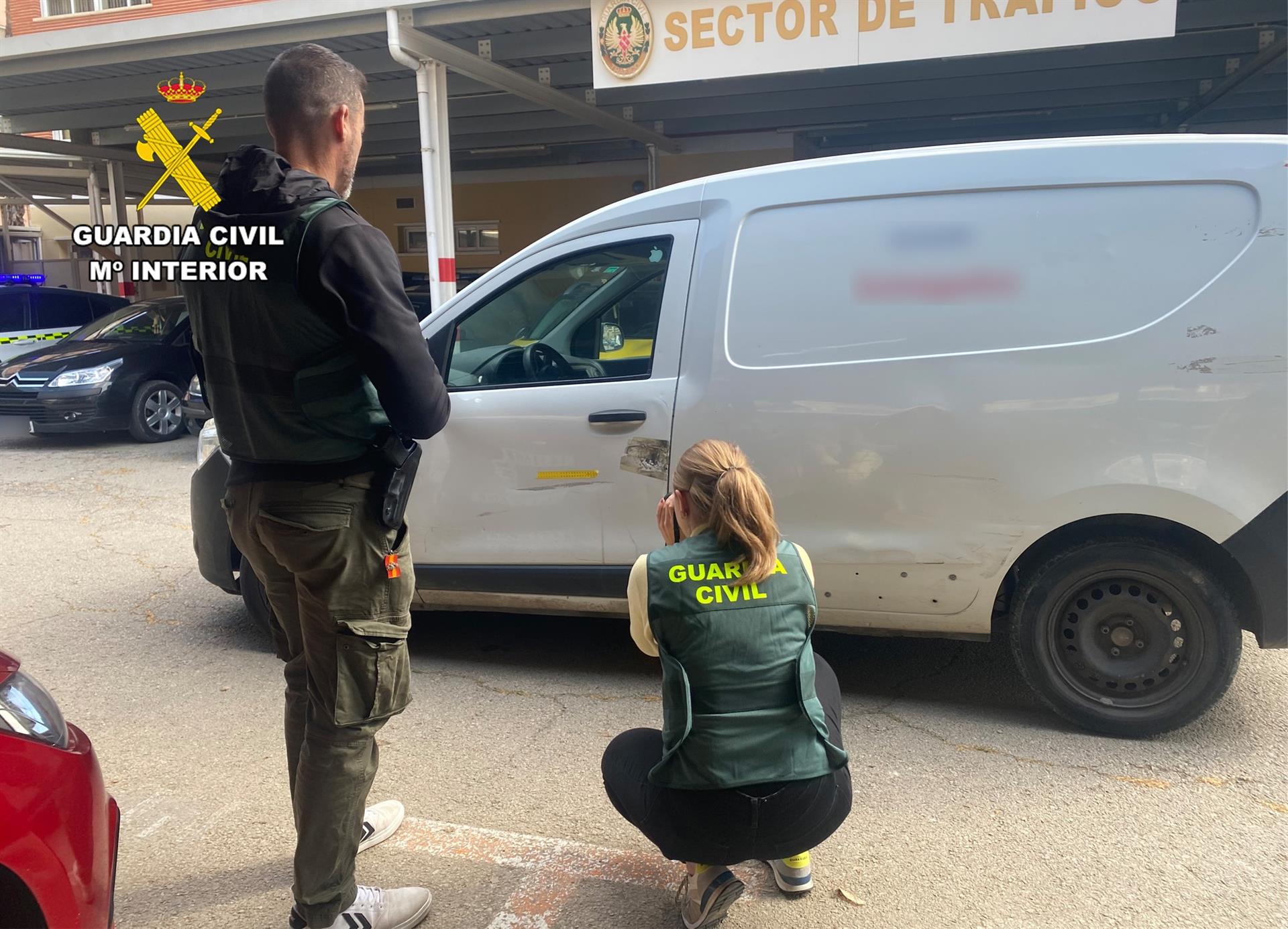 Dos agentes de la Guardia Civil junto a la furgoneta implicada en el siniestro