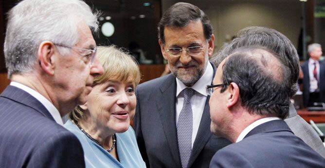 La canciller alemana, Angela Merkel, y el presidente francés, François Hollande, se saludan en presencia del jefe del Ejecutivo español, Mariano Rajoy