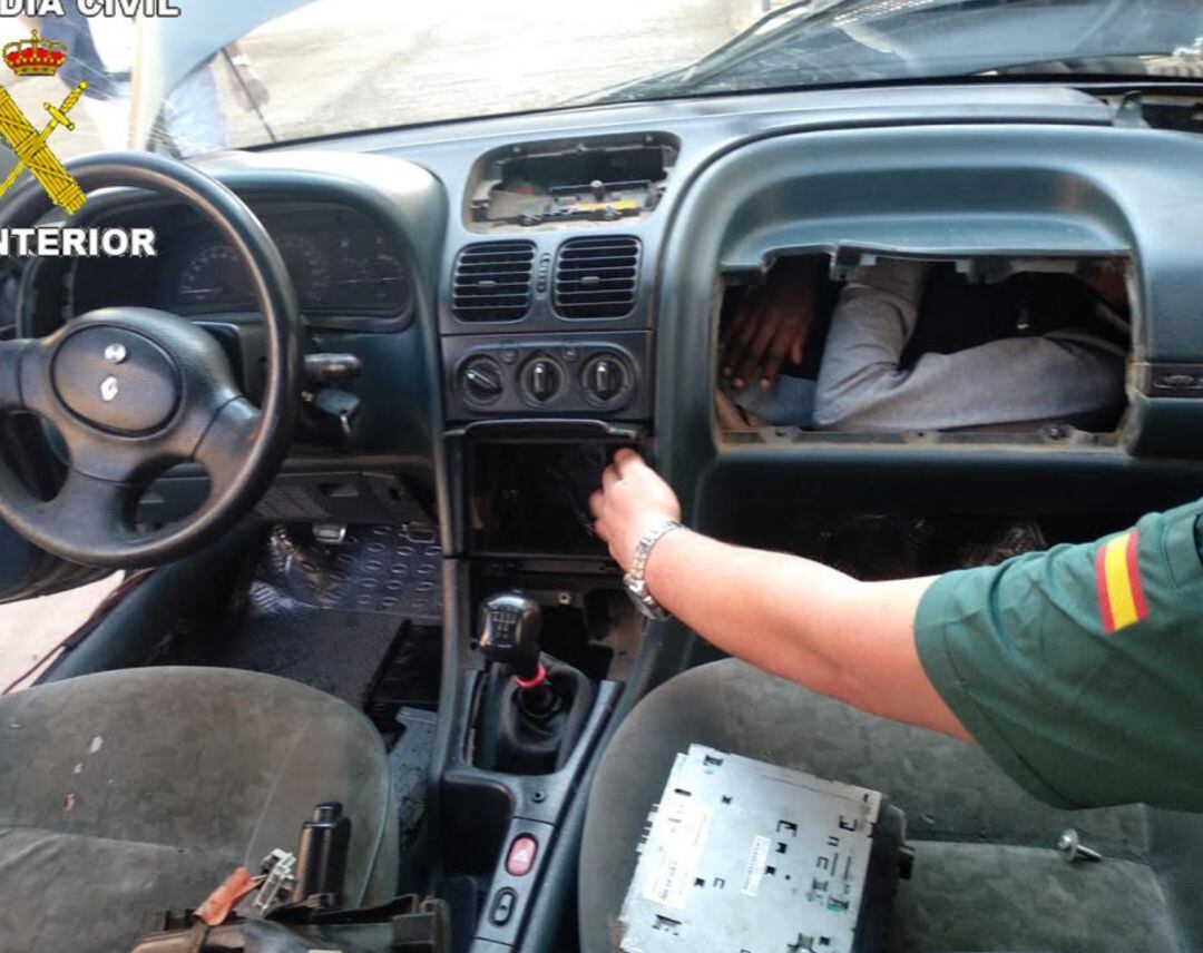 Agentes de la Guardia Civil descubren a una persona en el interior de un turismo.