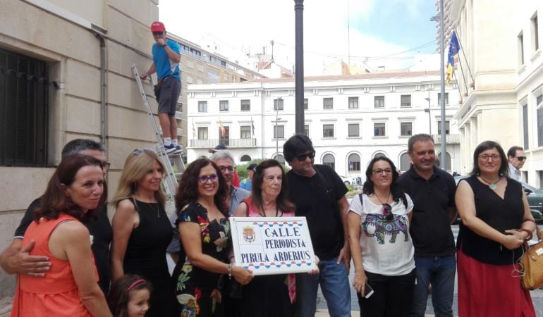 Pirula Arderius sostiene la placa de la calle con su nombre, primera que sustituye a una vía franquista, rodeada de los concejales de los cinco grupos municipales y de su hija y nieta.