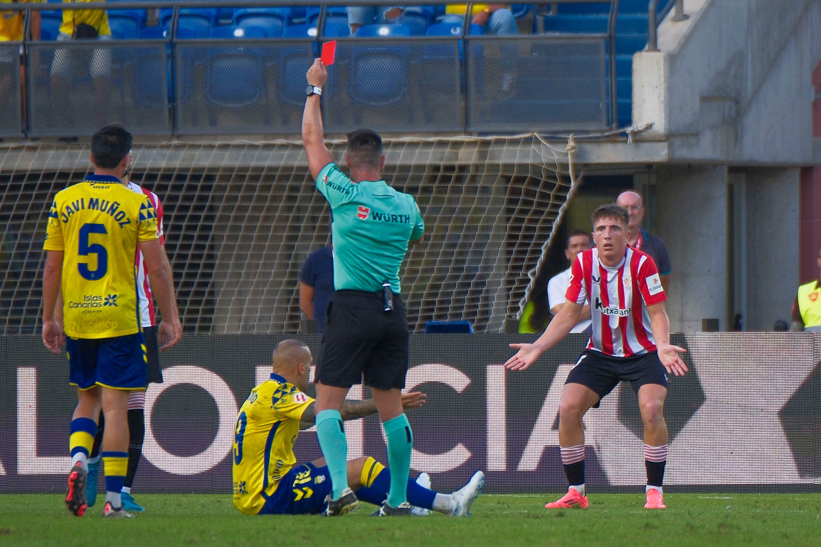 LAS PALMAS DE GRAN CANARIA, 15/09/2024.- El árbitro Ortiz Arias saca tarjeta roja a Mikel Jauregizar (d), del Athletic de Bilbao, durante el encuentro de la quinta jornada de LaLiga que UD Las Palmas y Athletic de Bilbao disputan hoy domingo en el estadio de Gran Canaria. EFE/Ángel Medina G.
