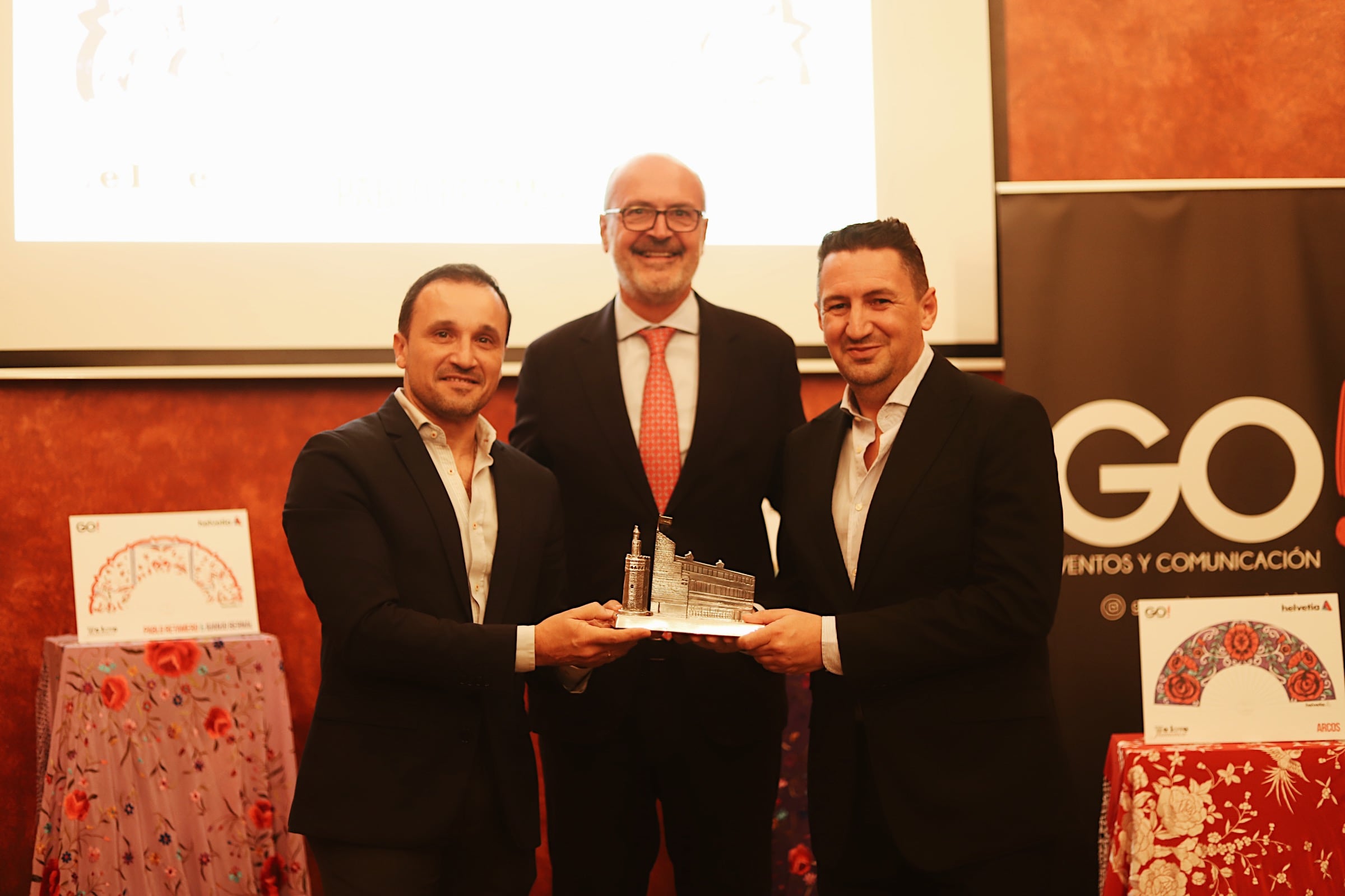 Íñigo Soto, director general de Helvetia Seguros, junto a Pablo Retamero y Juanjo Bernal, diseñadores gandores del abanico Feria de Abril 2024