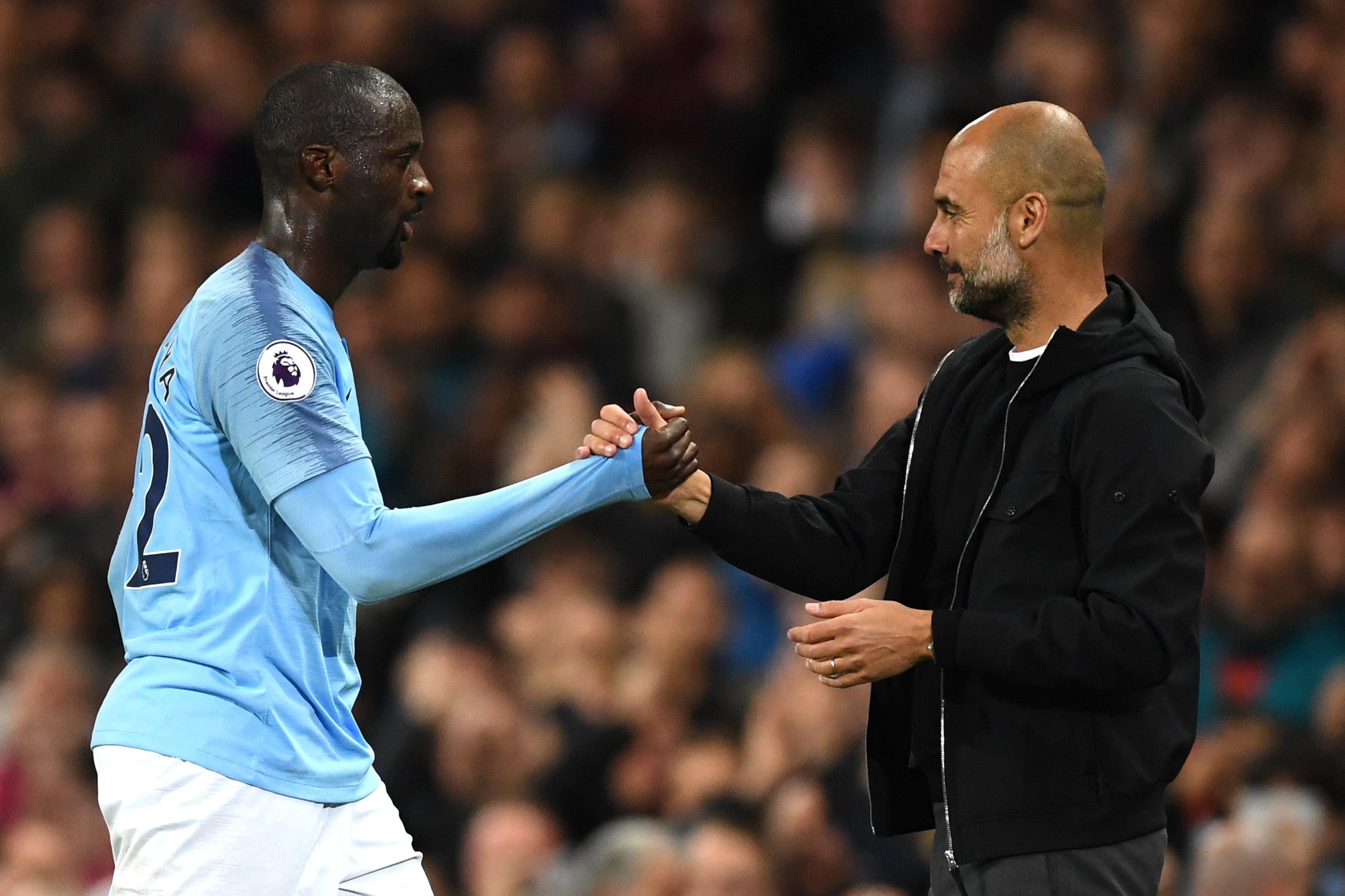 Yaya Touré y Guardiola se saludan durante un partido del Manchester City
