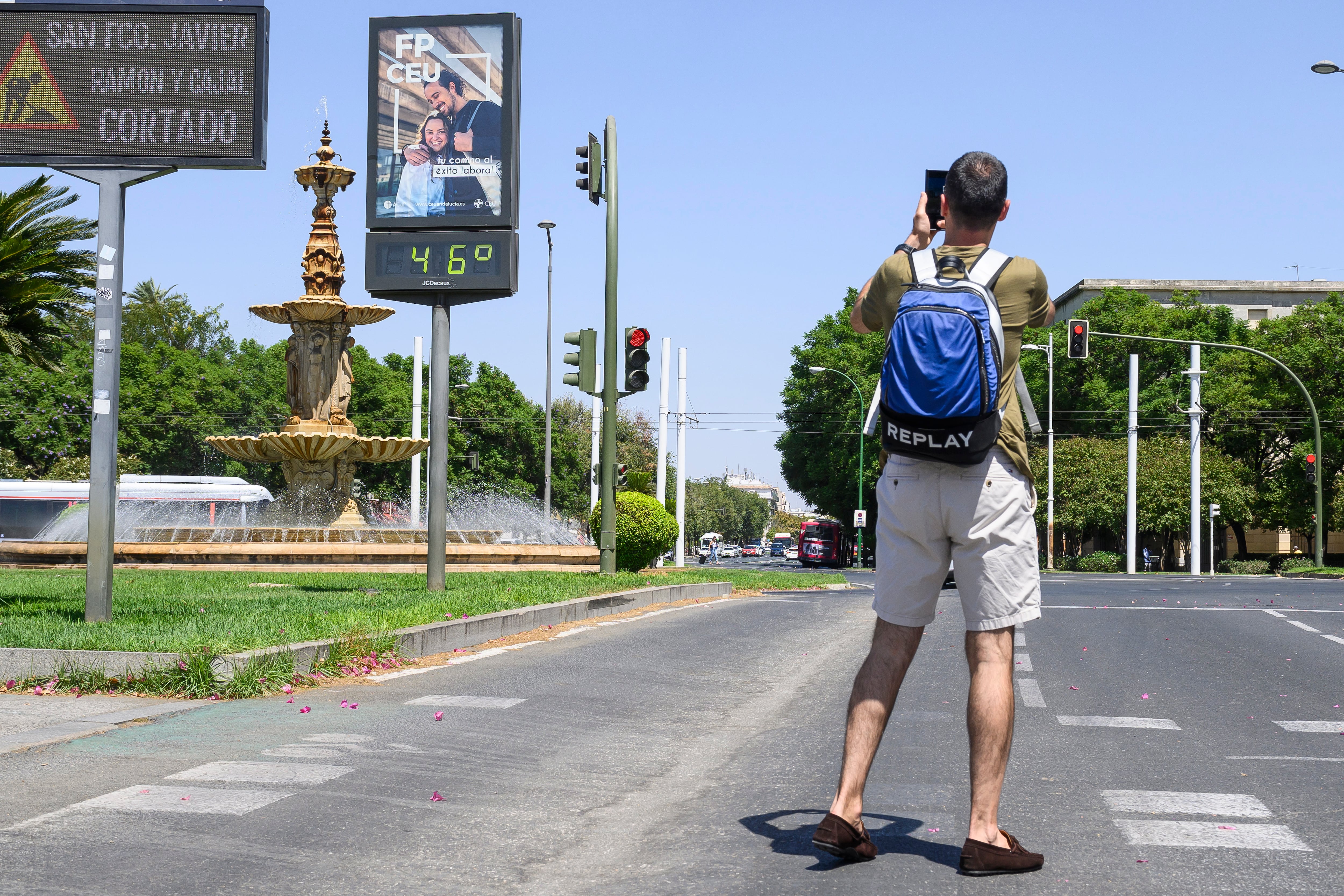 Un joven fotografía un termómetro en el centro de Sevilla durante la cuarta ola de calor del verano.