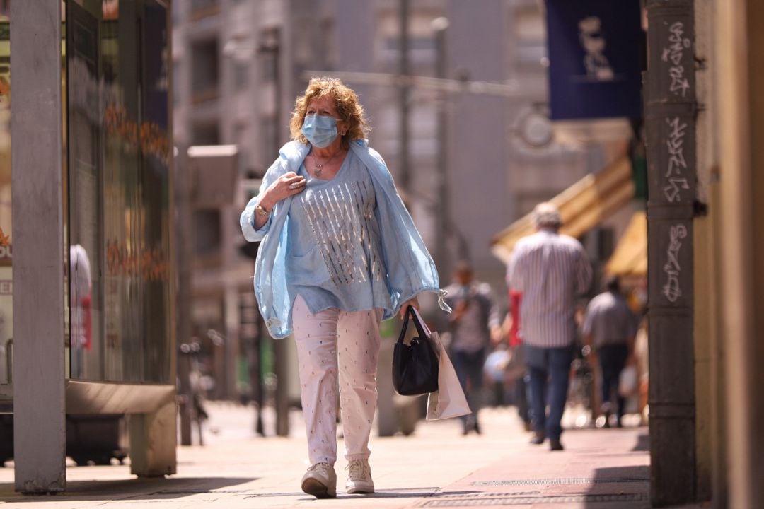 Una mujer pasea con mascarilla por una calle de Vitoria-Gasteiz,