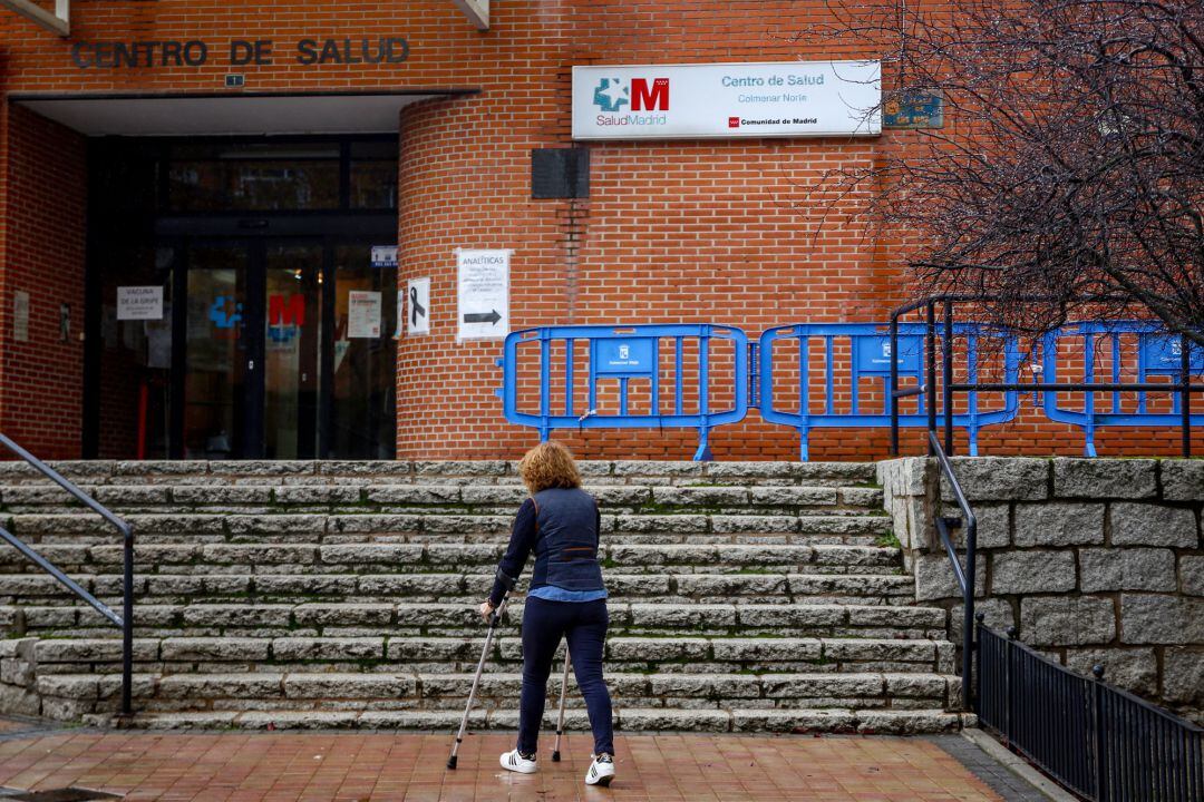 Una mujer sube con una muleta las escaleras del Centro de Salud de Colmenar Norte en Colmenar Viejo.