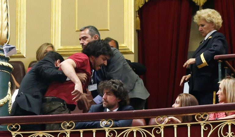 Víctor Taibo Gómez-Limón, hijo de una de las heridas en el accidente del Alvia en Santiago, tras lanzar un papel de protesta por la elección de Ana Pastor como presidenta del Congreso.