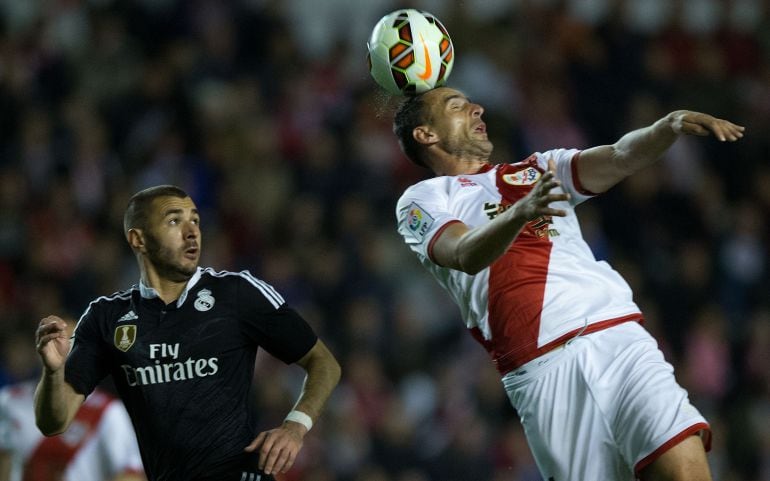 Antonio Amaya cabecea un balón ante la atenta mirada de Karim Benzema.