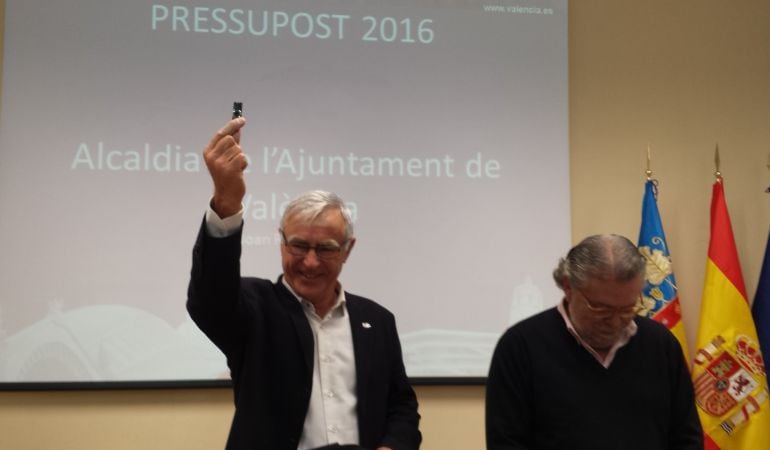 El alcalde Joan Ribó muestra el pen drive con el presupuesto del Ayuntamiento para 2016. Junto a él, el concejal de hacienda Ramón Vilar