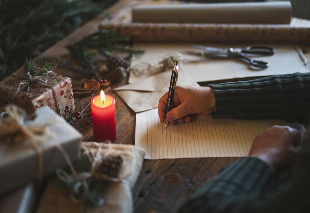 Un hombre escribe una carta por Navidad