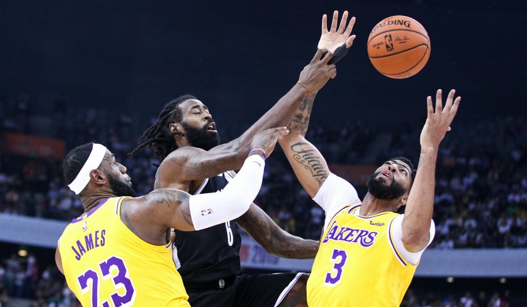 Anthony Davis y LeBron James pelean por llevarse la pelota ante DeAndre Jordan