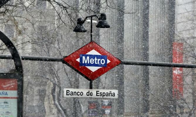 Vista de la estación de Metro de Banco de España durante la nevada que cae hoy sobre la capital