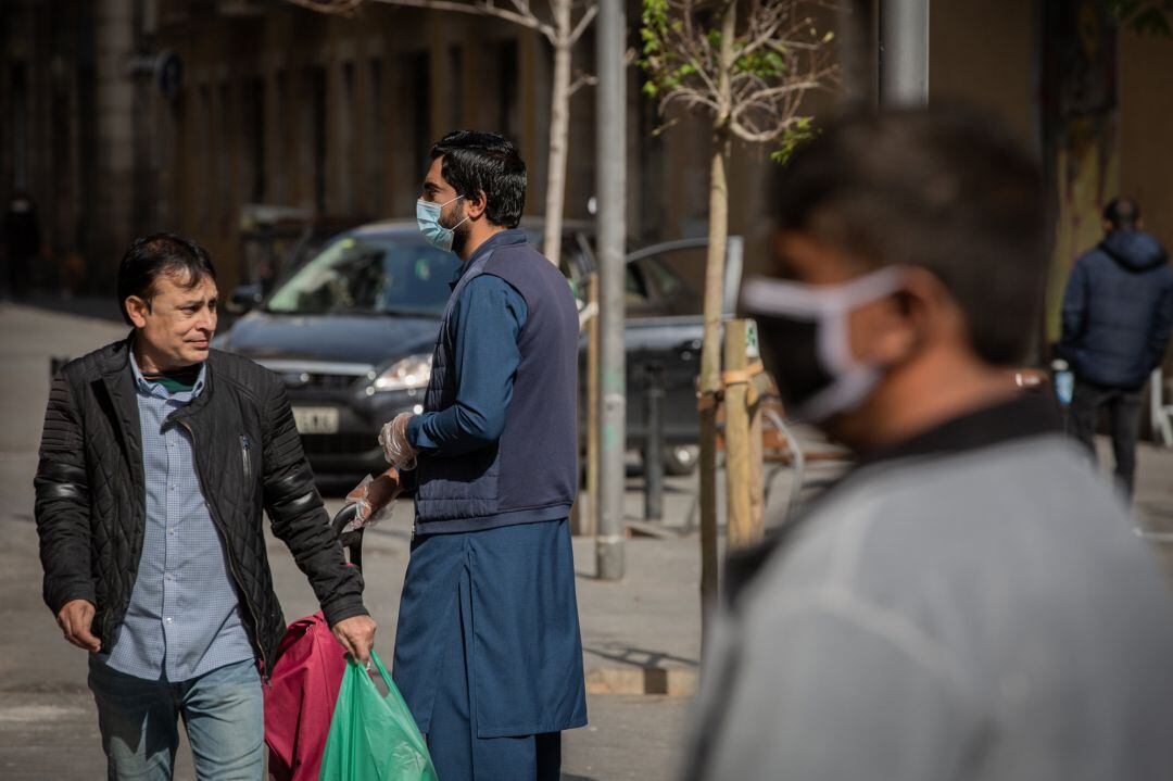 Varias personas protegidas con mascarillas durante el primer día laborable de la segunda semana desde que se decretó el estado de alarma en el país a consecuencia del coronavirus, en Barcelona.